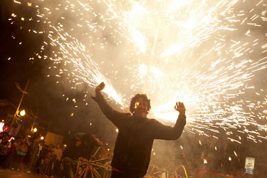 A man celebrates at a firework show during Carnival.