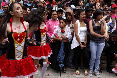 Girls, watched by a crowd of people, dance during the Carnival parade.