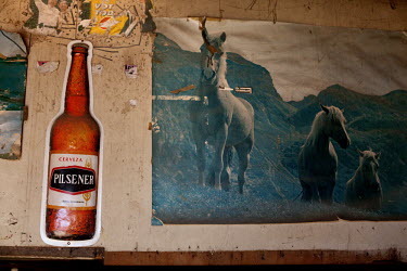 Posters of a bottle of beer and horses decorate the walls of a shop in Guanujo.
