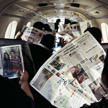 Passengers read newspapers while waiting for a domestic flight to take-off at Tribhuvan International Airport. Air travel is popular with business travellers as travel by road is slow and often danger...
