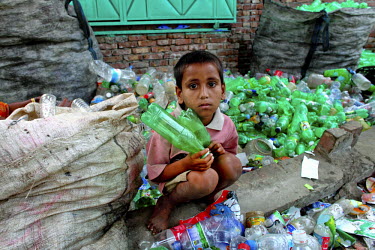 A young boy sorts through piles of plastic drinks bottles collected from Dhaka's streets in a factory producing PET (Polyethylene terephthalate) flakes. Bangladesh exports over 20,000 tonnes of PET fl...