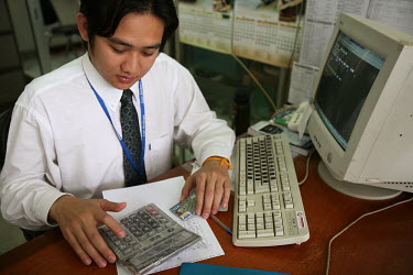 A clerk works at a computer in Vientiane.