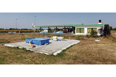 A swimming pool at the back of a petrol station.
