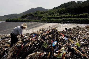 A man searches for recyclable items in a pile of newly dumped rubbish at the Changshengqiao landfill site on the city's outskirts.