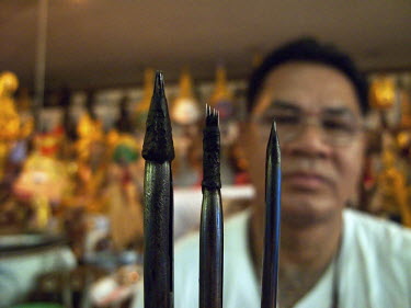 Tattoo master (khru Sak) Ajarn Montri shows various metal needles (mai sak) he uses to make his Sak Yan or Sacred Tattoos.