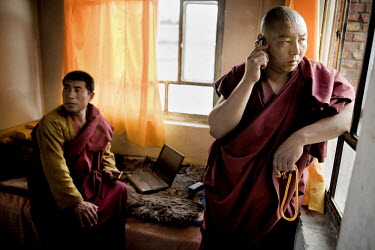 Ethnic Tibetan Buddhist monks in the Tongren monastery using mobile phones and laptop computers. Ethnic Tibetans make up about 21% of the population of Qinghai Province.