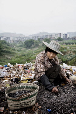 71 year old Fang Xin Nan scavenging on a rubbish dump outside the village of Luoqi.