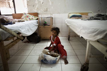 A child eats her lunch on the floor of the acute respiratory illness (ARI) treatment ward in the Civil Hospital. Acute respiratory illnesses and skin diseases are common consequences of malnutrition,...