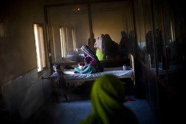 A woman holds her child on an acute respiratory illness (ARI) treatment ward in the THQ Hospital. Acute respiratory illnesses and skin diseases are common consequences of malnutrition, due to the brea...