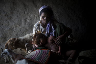 Anwar Bibi, 40, sits in her hut with her child, Sassi, 3. Anwar struggles to provide enough food for her children, as her husband is a drug addict who uses what little money the family has to cater hi...