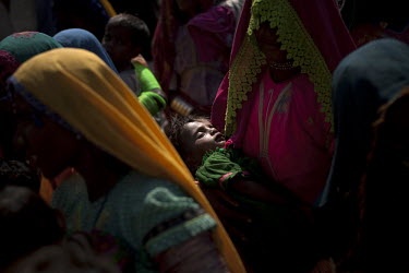 Women waiting with their children at a roadside camp to be treated at a mobile nutrition centre.  According to UN reports, hundreds of thousands of children in Pakistan suffer from severe-acute-malnut...