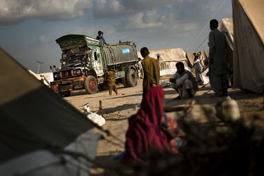 People displaced by flooding watch the arrival of a UNICEF water tanker.