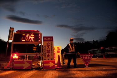 A man holds a stop sign on a road on the edge of the exclusion zone in Fukushima. On 11 March 2011 a magnitude 9 earthquake struck 130 km off the coast of Northern Japan causing a massive Tsunami that...