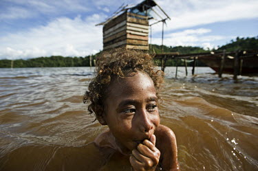 A child swims in the waters off Go Village in Mayalibit Bay. Deforrestation by the logging and mining industries has resulted in sediment being washed into the water, making it cloudy with pollutants....