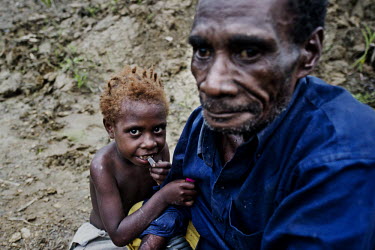 A Mooi man and child. The Mooi are one of the indigenous people who live off the forests of West Papua. Their ancestral lands are being devastated by logging and encroached on by palm oil plantations....
