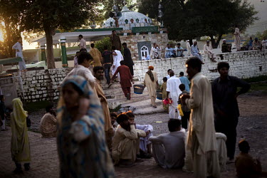 Impoverished families gather to receive a free meal of rice at Bari Imam Shrine in Islamabad. According to UN reports, hundreds of thousands of children in Pakistan suffer from severe-acute-malnutriti...