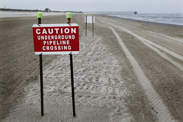 Warning signs mark a buried pipeline beneath the beach at the Grand Isle State Park. One year after the Deepwater Horizon oil spill the beach remains closed to visitors due to contamination. On 20 Apr...