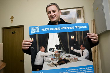 Alexander Victorovich Saranin, advertising director of Russkoe Moloko (Russian Milk), holds a calendar which shows a photo of Prime Minister Vladimir Putin sitting across a table from Dimitry Medvedev...