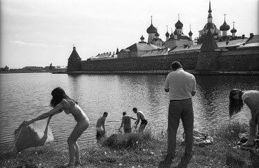 People bathe and sit on the shore near a 15th century monastery on the Solovetsky (Solovki) islands in the White Sea.