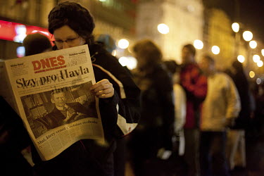 A woman reads a copy of Mlada Fronta Dnes, one of the biggest Czech newspapers, whose front page reads 'Tears for Havel'. The newspaper published a special edition after it was announced that Vaclav H...