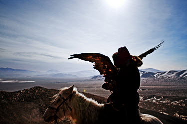 A Kazakh eagle hunter with his bird. The birds are carried on a thick glove and released, from horseback, to catch prey. The tradition is believed to originate in Central Asia some 6000 years ago and...