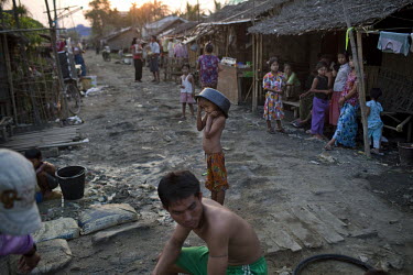 People wait to collect water in a slum on the outskirts of Yangon.