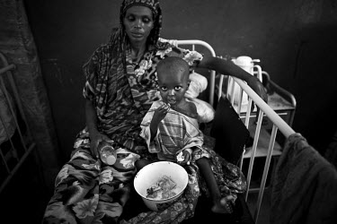 A malnourished child, sitting with its mother in a pediatric ward in Banadir Hospital, eats some food. The Horn of Africa is currently suffering the worst famine in 60 years and a s a result people ha...