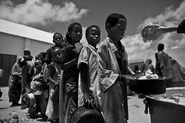 Children queue up for a food hand-out at a World Food Program (WFP) distribution point in a camp for IDPs (internally displaced persons). The Horn of Africa is currently suffering the worst famine in...
