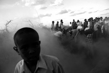 A boy stands near a mass grave being dug for eleven members of the same family who died as a result of malnutrition in the Dadaab refugee camp.  It is the largest refugee complex in the world, origina...