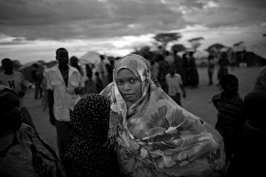 A woman stands among the many refugees who arrive each day at the Dadaab refugee camp after walking for many days from Somalia. The camp is the largest refugee complex in the world, originally set up...