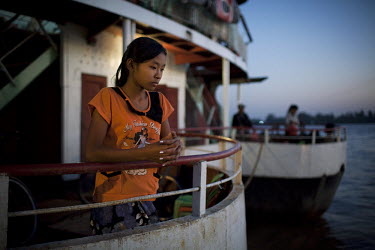 A young girl waits for a ferry to depart from the docks in Yangon.