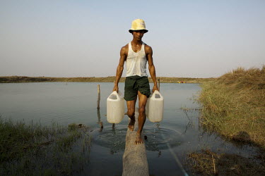 A villager collects water from a reservoir in Kwonku, the village where Myanmar President Thein Sein was born and grew up.