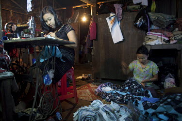 A woman sows in a small garment workshop in the constituency of NLD leader Aung San Suu Kyi where she competed and was voted in during a by-election in April 2012.