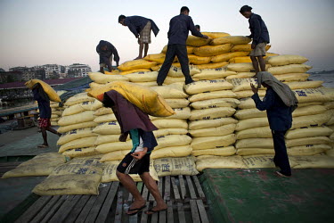 Dock workers unload bags of Chinese made chemicals at the docks in Yangon.