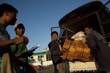 Dock workers unload a van in Yangon.