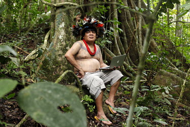 Almir Narayamoga (the one who unites) Surui, chief of the Surui (Paiter) tribe uses an Apple Mac computer at a meeting of tribal leaders in the village of Lapetanha, in the Brazilian Amazon. He is a w...