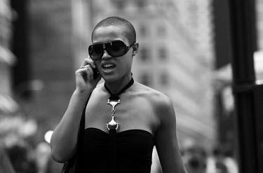 A young woman talks on her mobile phone while walking through Manhattan, New York.