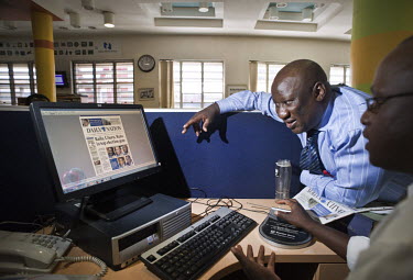 News editor Eric Shimoli checks the front page with a graphic designer in the offices of the Daily Nation newspaper.