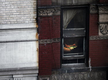 A pair of hands move tiles during a Majong game, in full flow, seen through the window of an apartment building in Manhattan's Chinatown, New York.