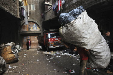 A man carries a huge sack of plastic, collected from throughout Cairo and destined for recycling by the Zaballeen, a minority group of Coptic Christians who have worked as Cairo's informal rubbish col...
