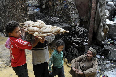 A group of young children carry food through the streets of the city. The garbage collectors, referred to as the Zabaleen, are a minority group of Coptic Christians who have worked as Cairo's informal...