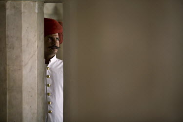 A turbaned guard looks through a column at the City Palace, Jaipur. The City Palace is a complex of palaces in central Jaipur built between 1729 and 1731 by Jai Singh II, the ruler of Amber.