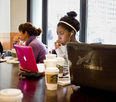A young woman surfs the net in a Starbucks cafe in Chicago, Illinois.