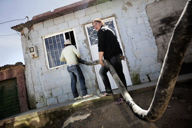 Local residents pump water from a truck into their home as they do not have any running water in the slum neighbourhood of La Isla, south of Bogota. Most of the people living here are internally displ...