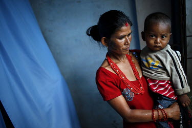 A woman and child wait for a family member to be treated at a reproductive health outreach camp in Sukute Village. Clients are not charged for sterilisation services, and are compensated 125 Nepali ru...
