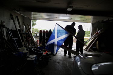 Gregor Edmunds from Scotland has been world caber tossing champon, No 1 Highland Games athlete in the world and World Highland Games champion 2007. Here he stands in a garage holding the national flag...