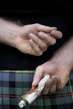 A competitor holds a tube of cream behind his back at the Callander Highland Games, Stirlingshire.