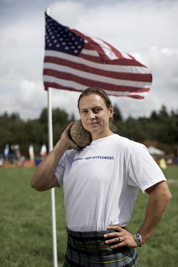 Adriane Blewitt, from the USA, holds a shot put and stands next to an American flag at the Callander Highland Games, Stirlingshire. Adriane was Ladies World Highland Games Champion in 2011.