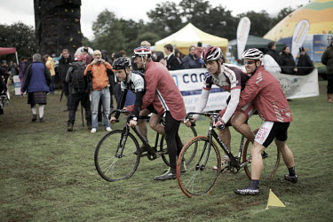 Men get a push start on the wet grass as they compete in the cycling event at the Pitlochry Highland Games in Perthshire.