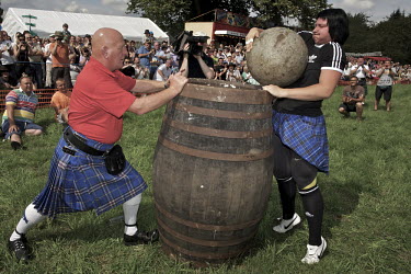 Nina Geria from Ukraine, lifts a weight onto a barrel, a task failed by male audience members at the Callander Highland Games, Stirlingshire.